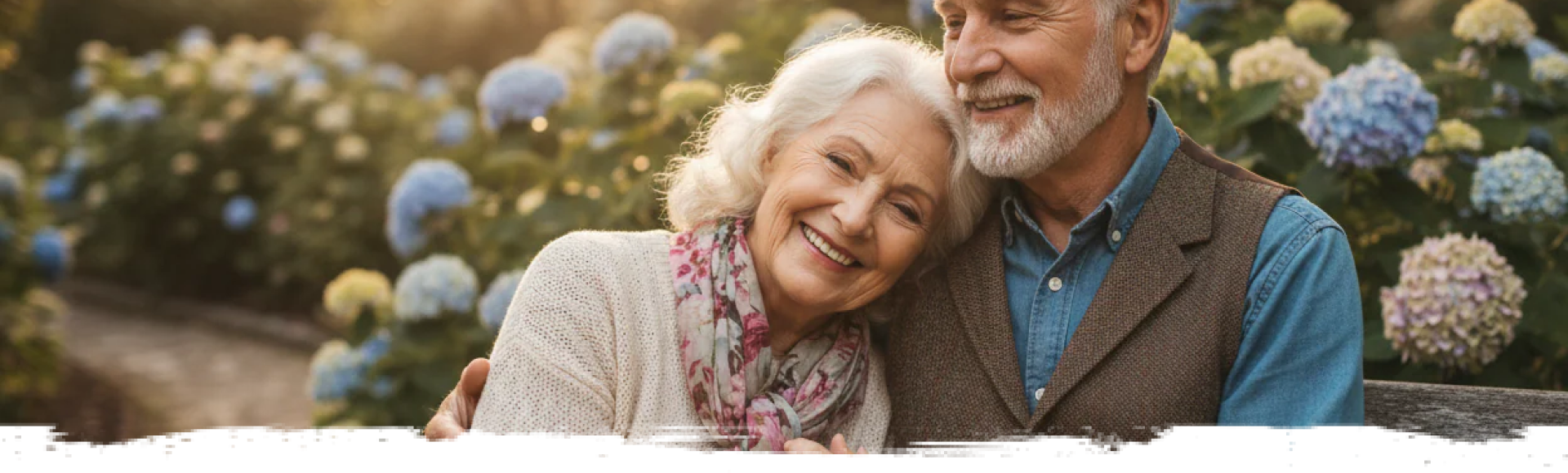 A senior couple, the woman leaning on the man’s shoulder, both smiling.